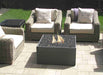 Solus Decor Firebox 30 in action with flames dancing over cinder rocks, surrounded by elegant garden chairs for a relaxed outdoor experience.