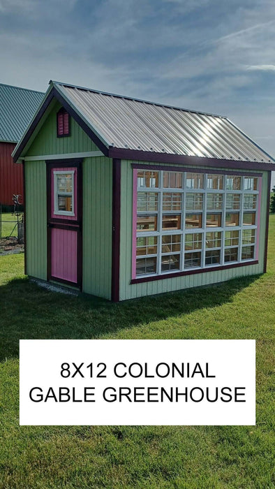 A vibrant Little Cottage Company Gable Greenhouse with contrasting trim and a metal roof against a farm backdrop.