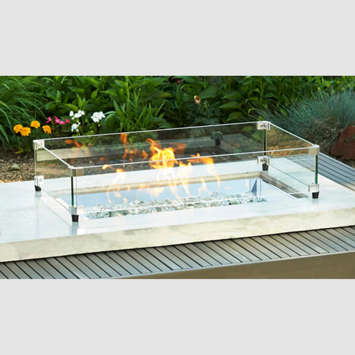 The Outdoor Greatroom Co Rectangular Glass Wind Guard used on a fire pit with flame.