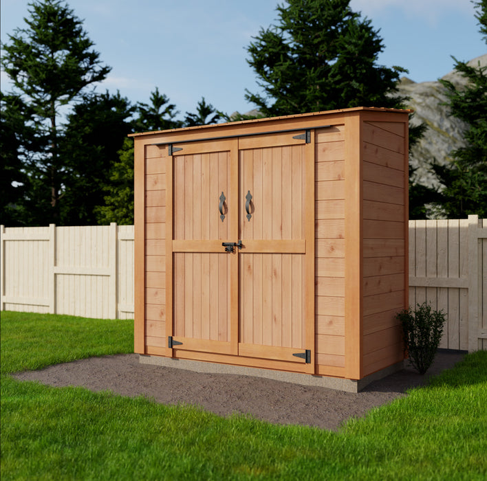 A wooden Outdoor Living Today 6x3 Garden Chalet with double door, situated on a grassy lawn beside a stone pathway, under a clear sky.