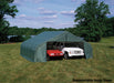 Green ShelterLogic portable garage with peak roof provides shelter for two cars