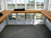 Interior of Little Cottage Company's Gable Greenhouse with wooden shelves and ample natural light.