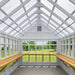 Interior of Little Cottage Company's Gable Greenhouse with wooden shelves and ample natural light.
