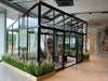 Exaco Janssens modern greenhouse displayed in a showroom with a stylish sloped roof, demonstrating the spacious and versatile interior for a variety of uses.