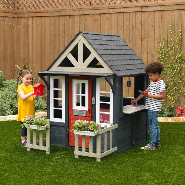 A Lakeside Bungalow Playhouse with kids in the backyard