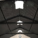 Inside view of the Lifetime shed's roof structure, displaying the trusses and central skylight.