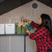 A woman interacting with items on a shelf attached to the walls of a storeroom