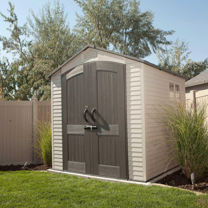 Lifetime 7x7 ft Outdoor Storage Shed in a garden setting with surrounding greenery and fence.