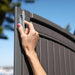 Woman's hand adjusting a roof latch on the Lifetime 8 x 17.5 ft Outdoor Storage Shed for secure closure.