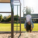 A child hanging upside down from the trapeze bar on the Lifetime 91080 Deluxe Swing Set.