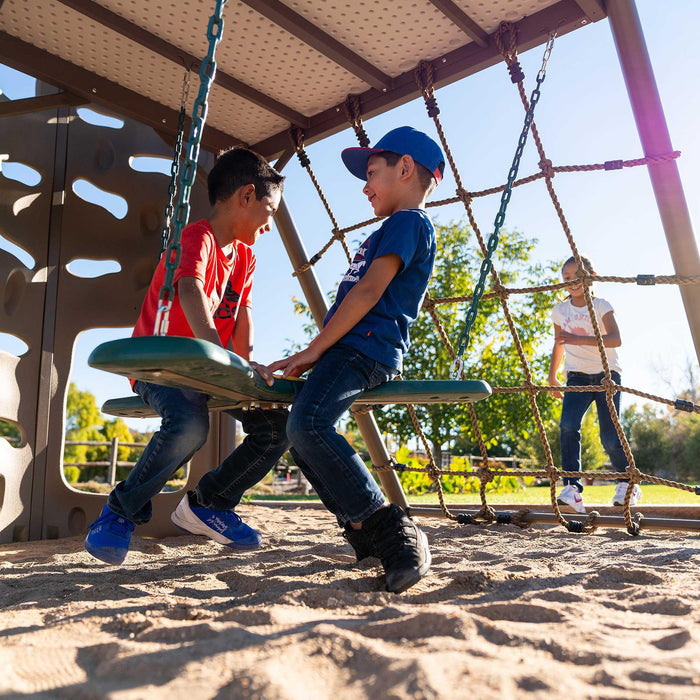 A child and his friend playing on the propeller swing of the Lifetime 91080 Swing Set.