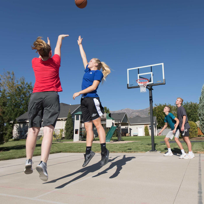 Two players mid-game with the Lifetime Adjustable Bolt Down Basketball Hoop in the background.