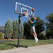 A player attempting a dunk on the Lifetime Adjustable Bolt Down Basketball Hoop.