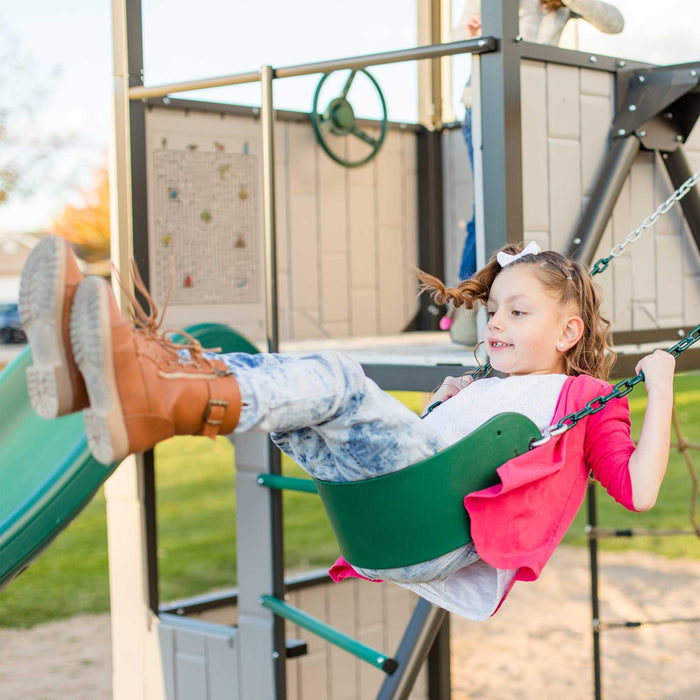 A child in motion swinging on the Lifetime Adventure Clubhouse Playset with a focus on the enjoyment of play.