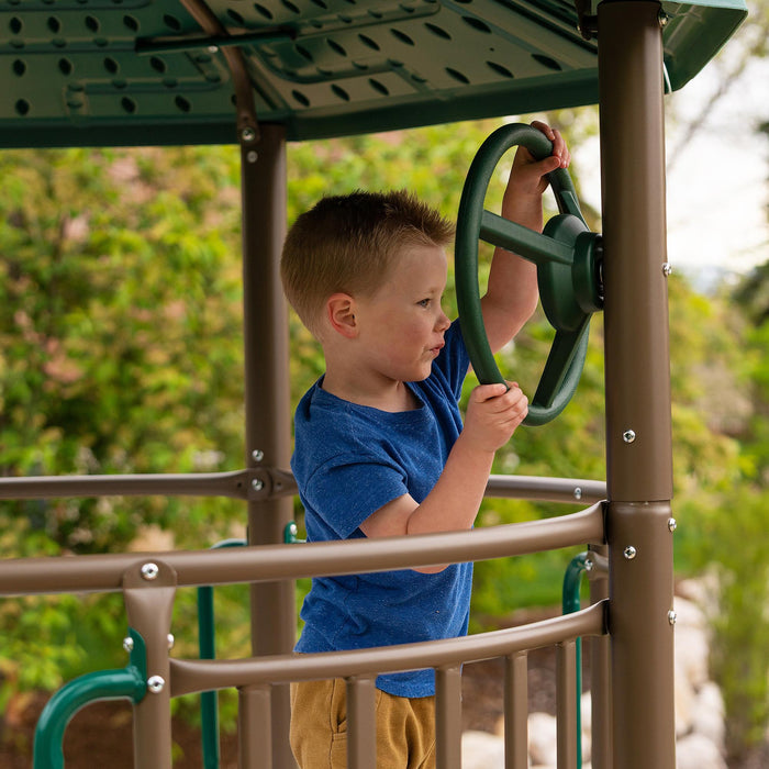 A child playing with the steering wheel feature on the Lifetime Adventure Slide Tower.