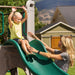 Child being assisted by an adult while playing on the slide of the Lifetime Adventure Tower Playset, SKU 91200