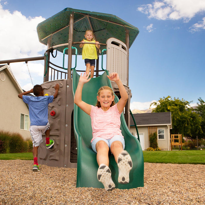 Children playing on the slide and climbing the rock wall of the Lifetime Adventure Tower Playset, SKU 91200.