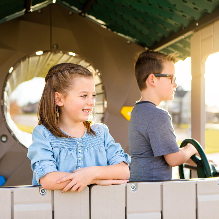 Children interacting on the tower platform of the Lifetime Adventure Tunnel Playset with a steering wheel and lookout.