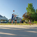 A group of young players in an outdoor game of basketball using the Lifetime Crank Adjust Bolt Down Basketball Hoop in a residential driveway.