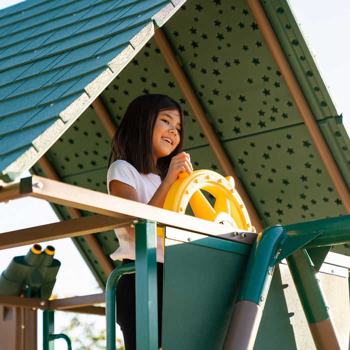 A child playing with the ship's wheel at the clubhouse of the Lifetime Big Stuff Deluxe Playset.