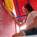 Child drawing on the red chalkboard feature of the Lifetime Big Stuff Deluxe Swing Set, model 91087.