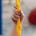 Close-up of a child's hand holding the yellow chain of the Lifetime Big Stuff Deluxe Swing Set, showcasing the equipment's safety and durability.