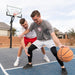 Two young men playing basketball with the Lifetime Mammoth Hoop in an outdoor home court setting.