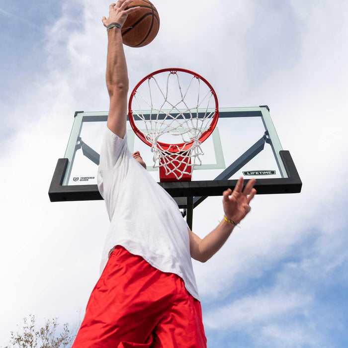 Player attempting a dunk on the Lifetime Mammoth Basketball Hoop.