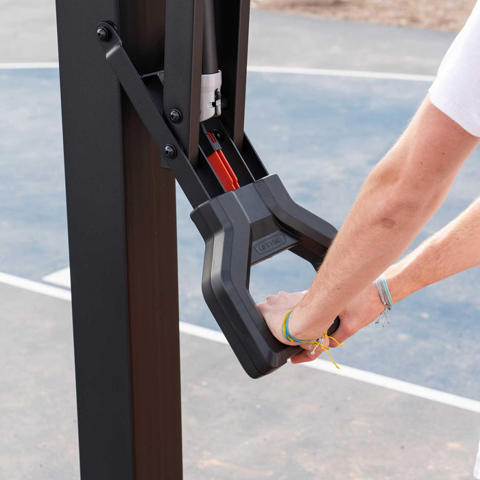 Close-up of a player's hand adjusting the height lever on the Lifetime Mammoth Basketball Hoop.