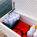  Lifetime Marine Dock Box, model 60348, open and filled with towels, life jackets, and containers, situated on a dock by the water.