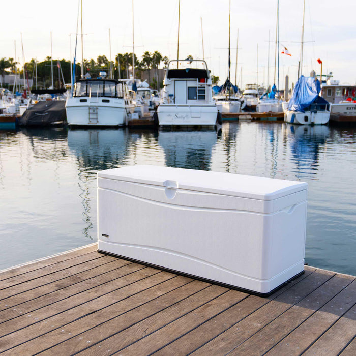 Lifetime Marine Dock Box, model 60348, placed on a dock with a background of boats and water in a marina setting.