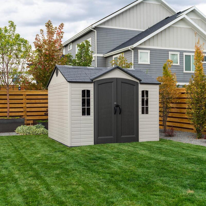 The Lifetime 10 x 8 ft. Outdoor Storage Shed situated in a backyard garden setting.