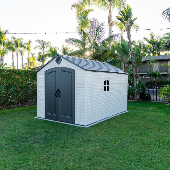 The Lifetime 8 ft x 12.5 ft Outdoor Storage Shed captured in the evening, showcasing its aesthetic and build in a home garden setting.