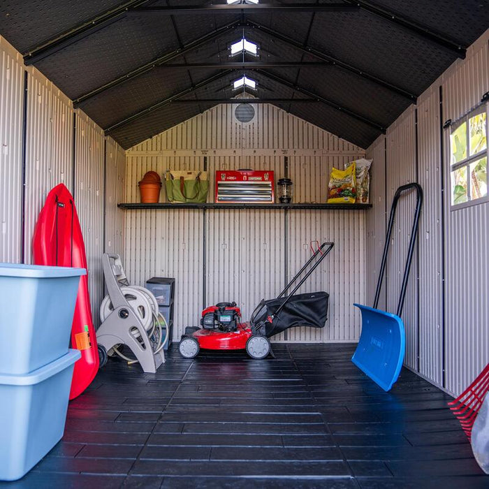 Interior view of the Lifetime 8 ft x 12.5 ft Outdoor Storage Shed with organized storage solutions including shelves and a lawnmower.
