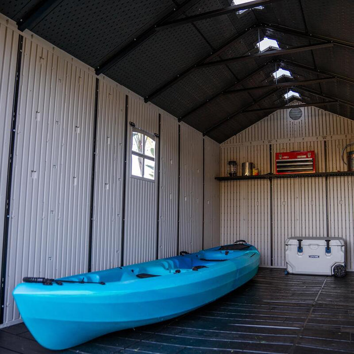 Interior view of Lifetime 8 Ft. x 15 Ft. Outdoor Storage Shed showing a blue kayak and white cooler.