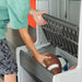Child storing a football and soccer ball in the lower compartment of the Lifetime storage locker.