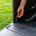 Close-up of a person's hand unlatching the door of the Lifetime 10 x 8 ft. Outdoor Storage Shed.