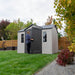 Person opening the door of the Lifetime 10 x 8 ft. Outdoor Storage Shed in a residential backyard.