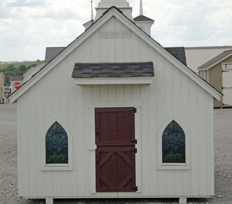 The Little Cottage Chapel Playhouse with glass windows and red door.