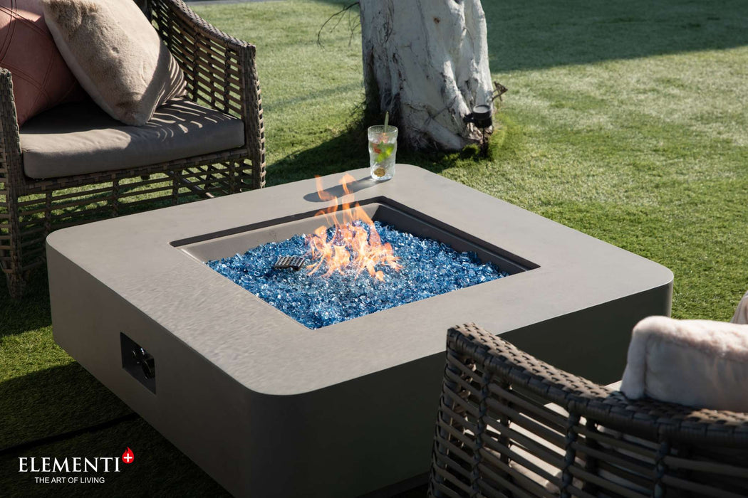 Elementi Plus Lucerne Square Concrete Fire Pit Table on a lush green yard