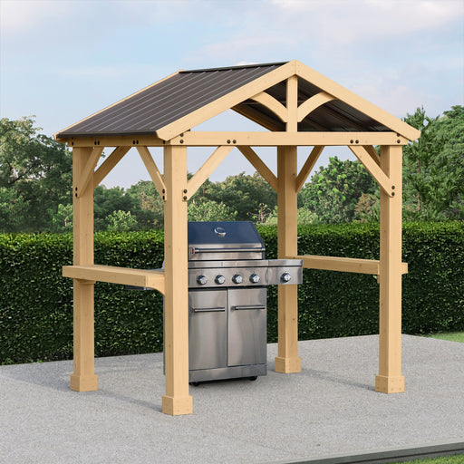 Fully assembled Yardistry Grilling Pavilion in a garden setting with outdoor griller under its shelter.