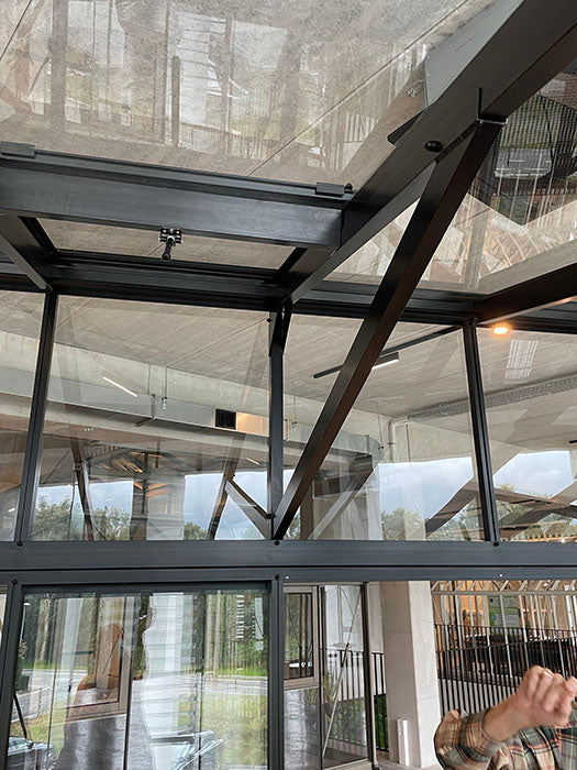 Detailed interior view of the Exaco Janssens M23 greenhouse's modern structure with its sloping roof and sophisticated framing.