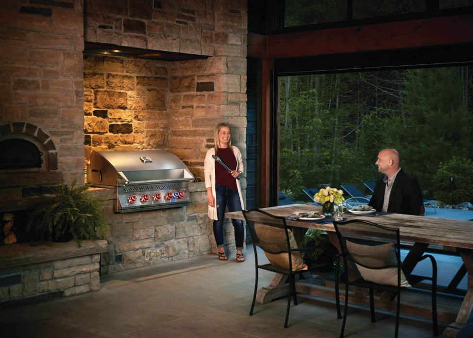 An outdoor poolside dining experience highlighting the Napoleon Grills Built-In 700 Series 38-Inch Gas Grill Head, where people are gathered for an evening of grilling and relaxation.