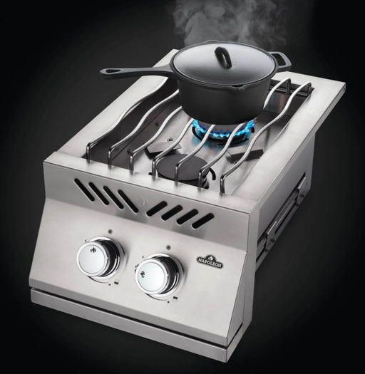 Angled view of Napoleon Grills Built-In 500 Series 10-inch single range top burner with a pot on the grate and flame on.