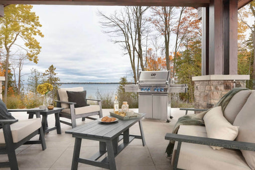 The Napoleon Grills Prestige PRO™ 500 RSIB set in an outdoor patio environment with lake view, highlighting the grill's sleek design and outdoor adaptability.