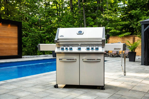 Lifestyle image of the Napoleon Grills Prestige® 665 RSIB next to a pool, highlighting the grill in an outdoor setting.