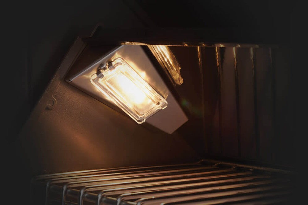 The interior grill lights illuminating the cooking area of the Napoleon Grills Built-In Prestige PRO™ 825 RBI Gas Grill Head.