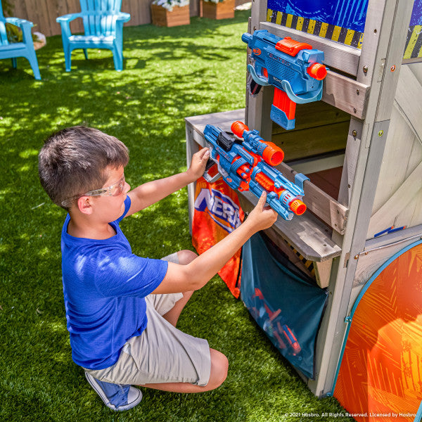 Kid holding a nerf on the defense post playset