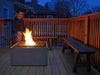 An atmospheric evening view of a lit Solus Decor Firebox 30 on a deck, creating a warm and inviting outdoor space.