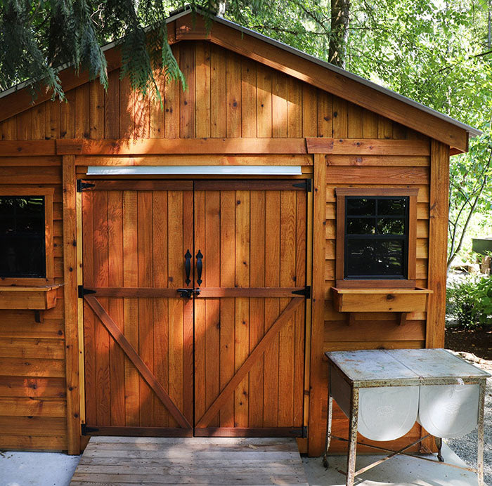 Outdoor Living Today Space Master Wooden Storage Shed 12x16 with ramp and on a cement foundation with trees in the back